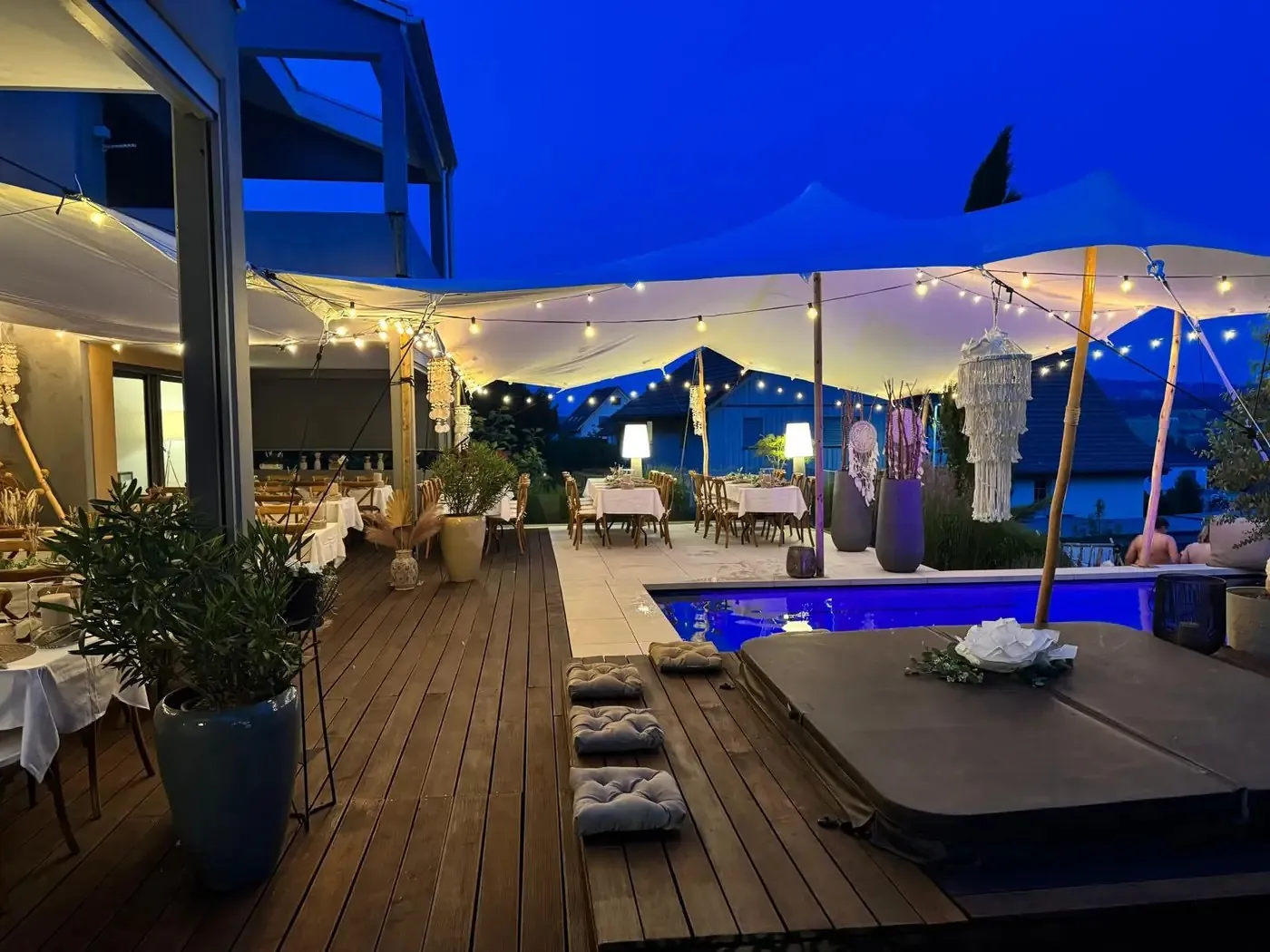 Weisses Stretchzelt am Abend über einer Terrasse mit Lounge