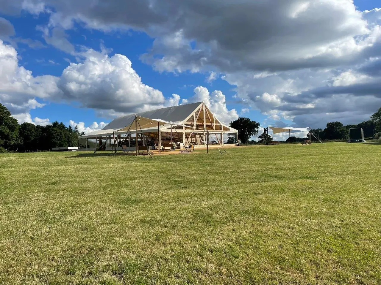 Event Chalet von aussen auf einer grossen Wiese unter blauem Himmel