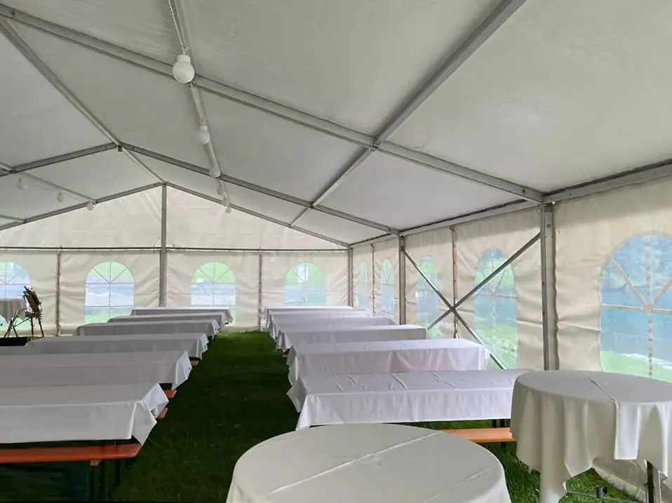 Festzelt innen mit Festgarnituren auf einer Wiese
