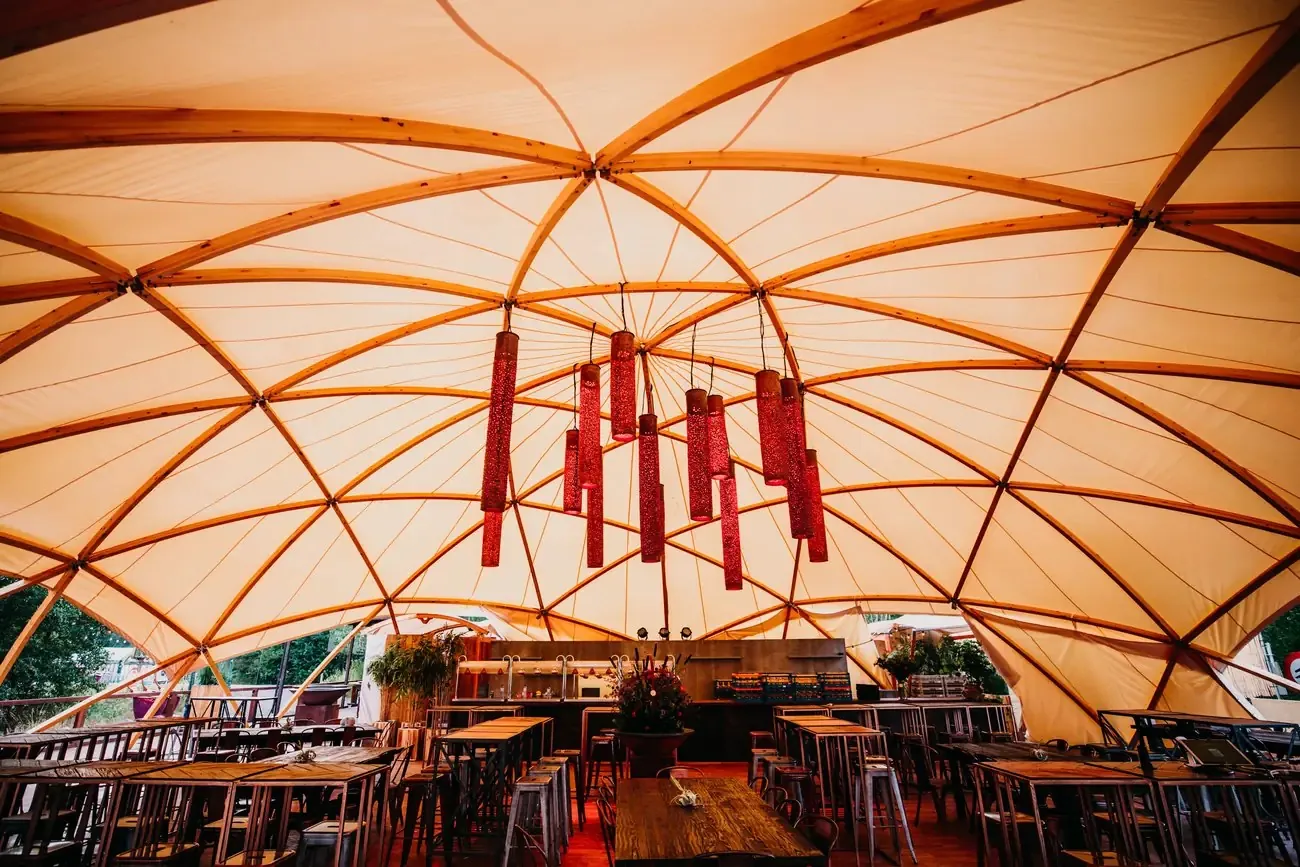 Flat Dome innen mit Holzbögen, Segeltuch und einer Bar