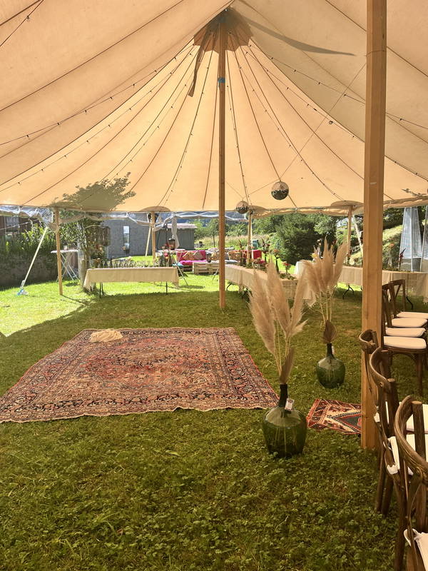 Zelt mit Teppich und Pampasgras in einem Garten