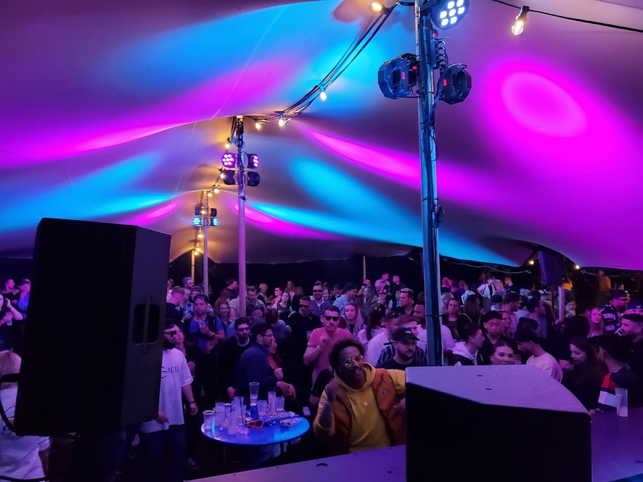 Party in einem violett beleuchteten Zelt